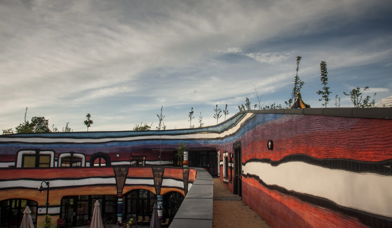 Nieuwbouw Ronald McDonald Kindervallei Valkenburg – golvende, kleurrijke gevels in Hundertwasser-stijl met daktuin en looproute rond de binnenhof