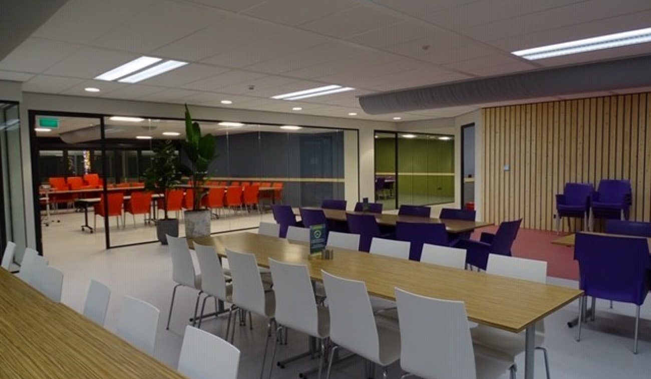 Meeting Plaza Utrecht: glazen vergaderbox met bergfotowand, grote plant en ronde tafel