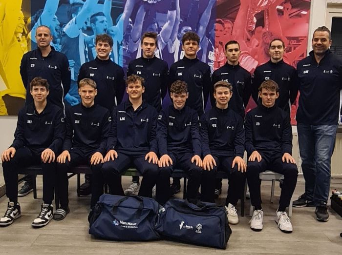 Een sportteam poseert voor een team foto met op de voorgrond twee sporttassen