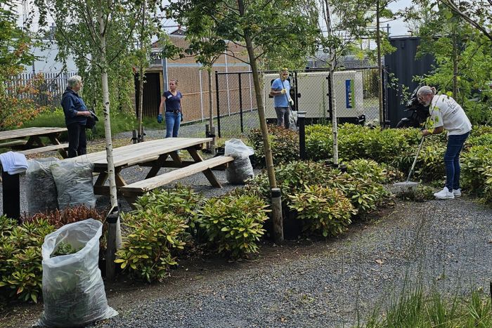 Verschillende mensen zijn aan het werk om een tuin te onderhouden