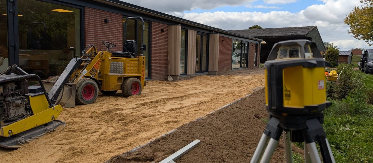 Een gebouw waar aan gewerkt wordt met aan de voorgrond graafmachines
