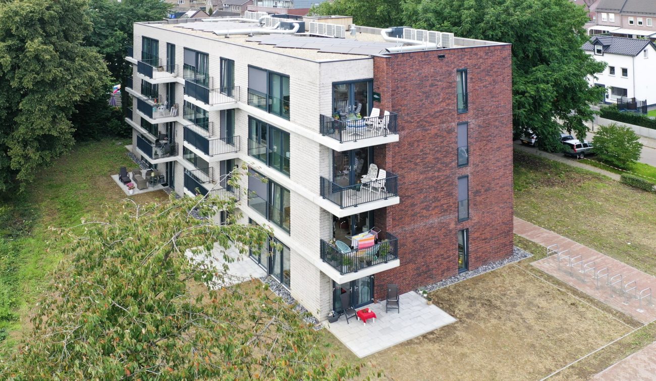 Luchtfoto nieuwbouw sociale huurappartementen Margraten met balkons en tweekleurig metselwerk.
