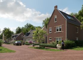 Vrijstaande bakstenen woningen in Bosrijk Mariendaal (Velp) langs rood klinkerwegdek; groenstroken, geparkeerde auto’s en wandelaar met kinderwagen, zonnige dag.