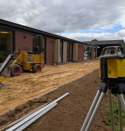 Een gebouw waar aan gewerkt wordt met aan de voorgrond graafmachines