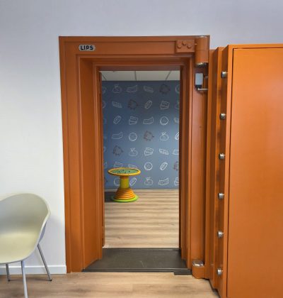 Geopende kluisdeur met houten afwerking en zicht op beveiligde binnenruimte