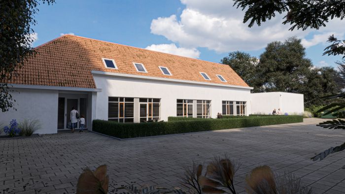 Impressie transformatie oude school Buchten: wit stuc, oranjerood dak, haag en verhard terras