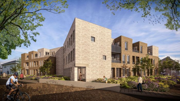 D’r Burggraaf Gulpen – impressie van hoekblok in licht en donker baksteen met balkons, entreepassage en bloemrijke beplanting