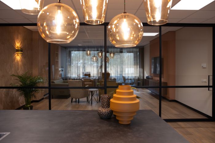 Zicht op een woonkamer, met voorin hangende lampen