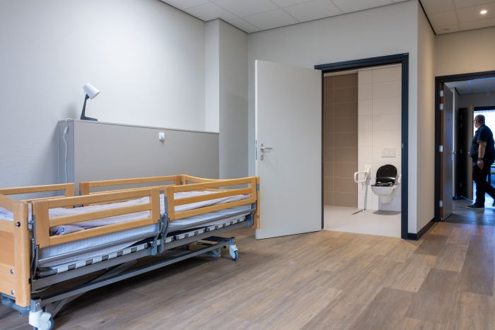 Een kamer met een bed en een WC
